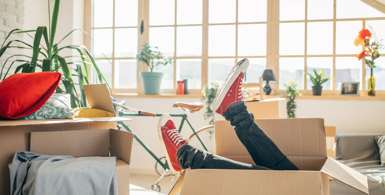 Man lying down on sofa in home with cardboard boxes stock photo